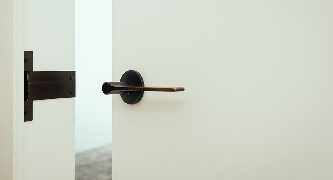 close up of door handle on white wall